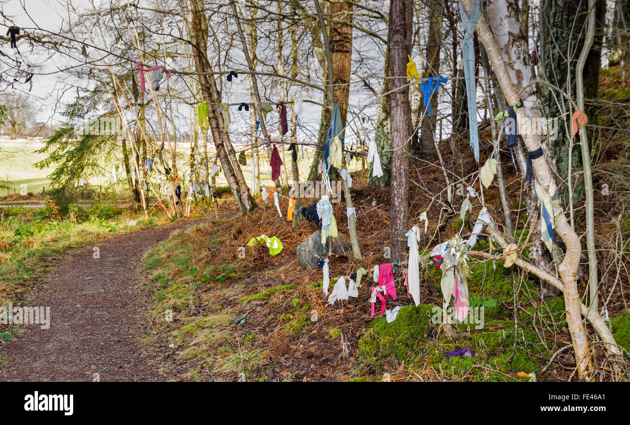 CLOOTIE GUT MUNLOCHY BLACK ISLE SCHOTTLAND WANDERWEG FÜHRT ZUM BRUNNEN UND KLEIDUNGSSTÜCKE, DIE ZWEIGE HÄNGEN Stockfoto