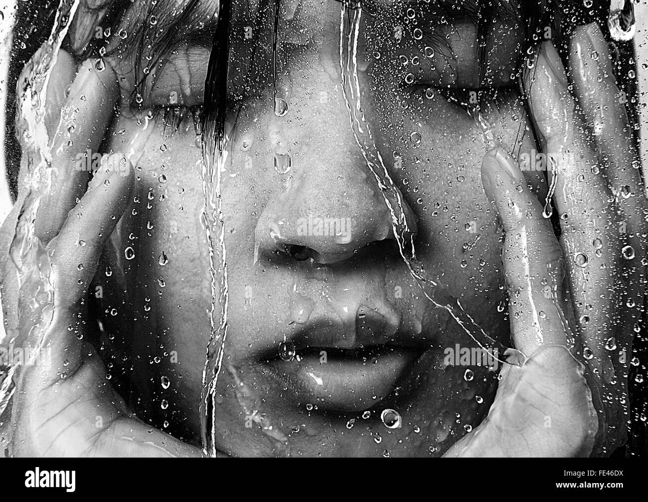 Frau In der Dusche durch nasses Glas gesehen Stockfoto
