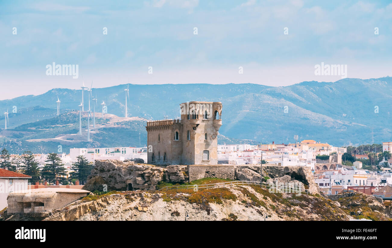 Alte mittelalterliche Burg Turm vor dem Hintergrund der Stadtlandschaft in einer bergigen Gegend in Tarifa, Andalusien Spanien. Stockfoto