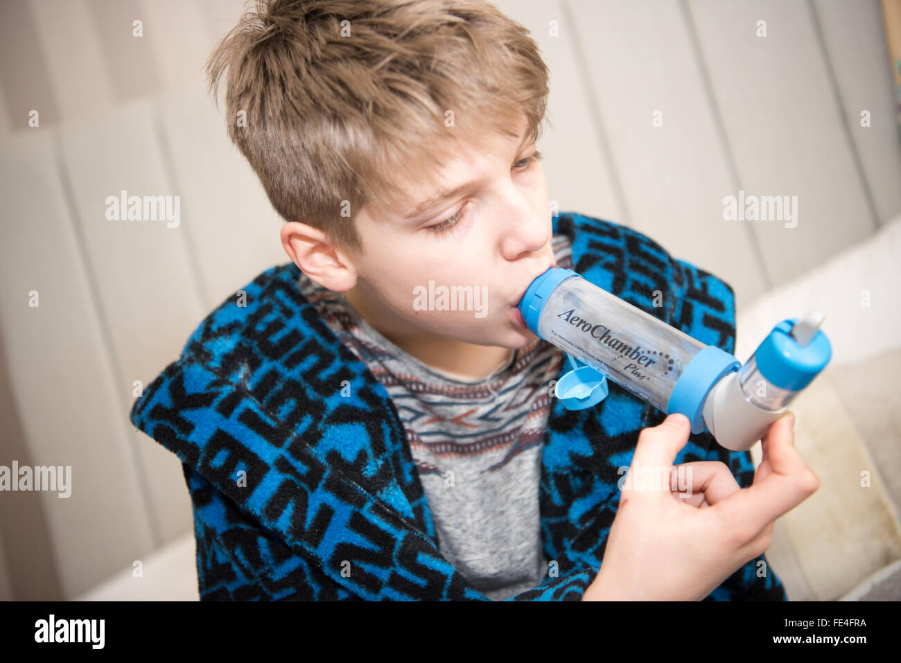 Schlecht weiße Teenager leiden eine gefährlicher Asthmaanfall atmeten durch ein Distanzstück und seinen Inhalator Ventolin erhalten, um ihm zu helfen, Atem Stockfoto