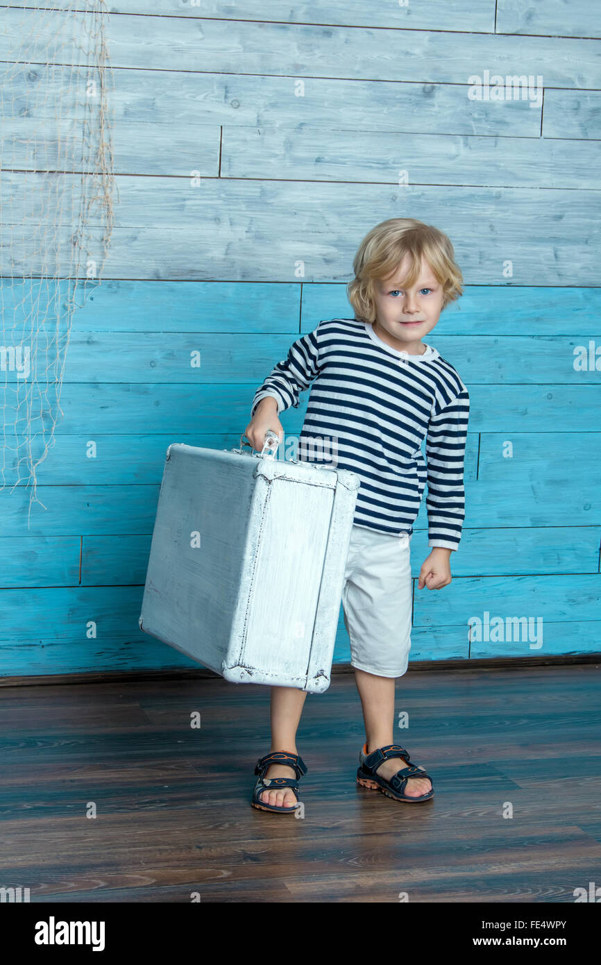 Kind ist einen Koffer tragen. Stockfoto