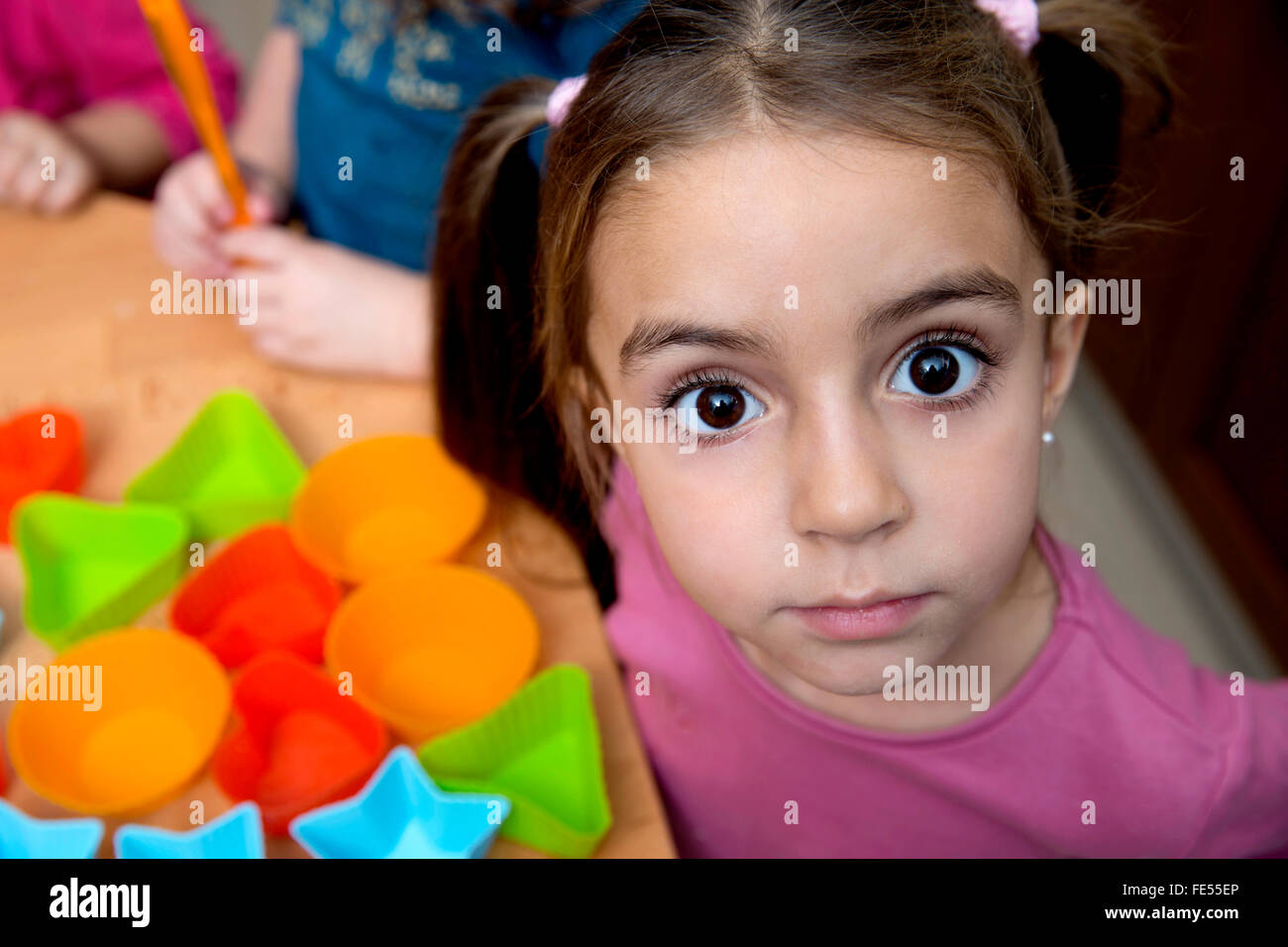 Lustige kleine Mädchen Grimassen beim Blick in die Kamera Stockfoto