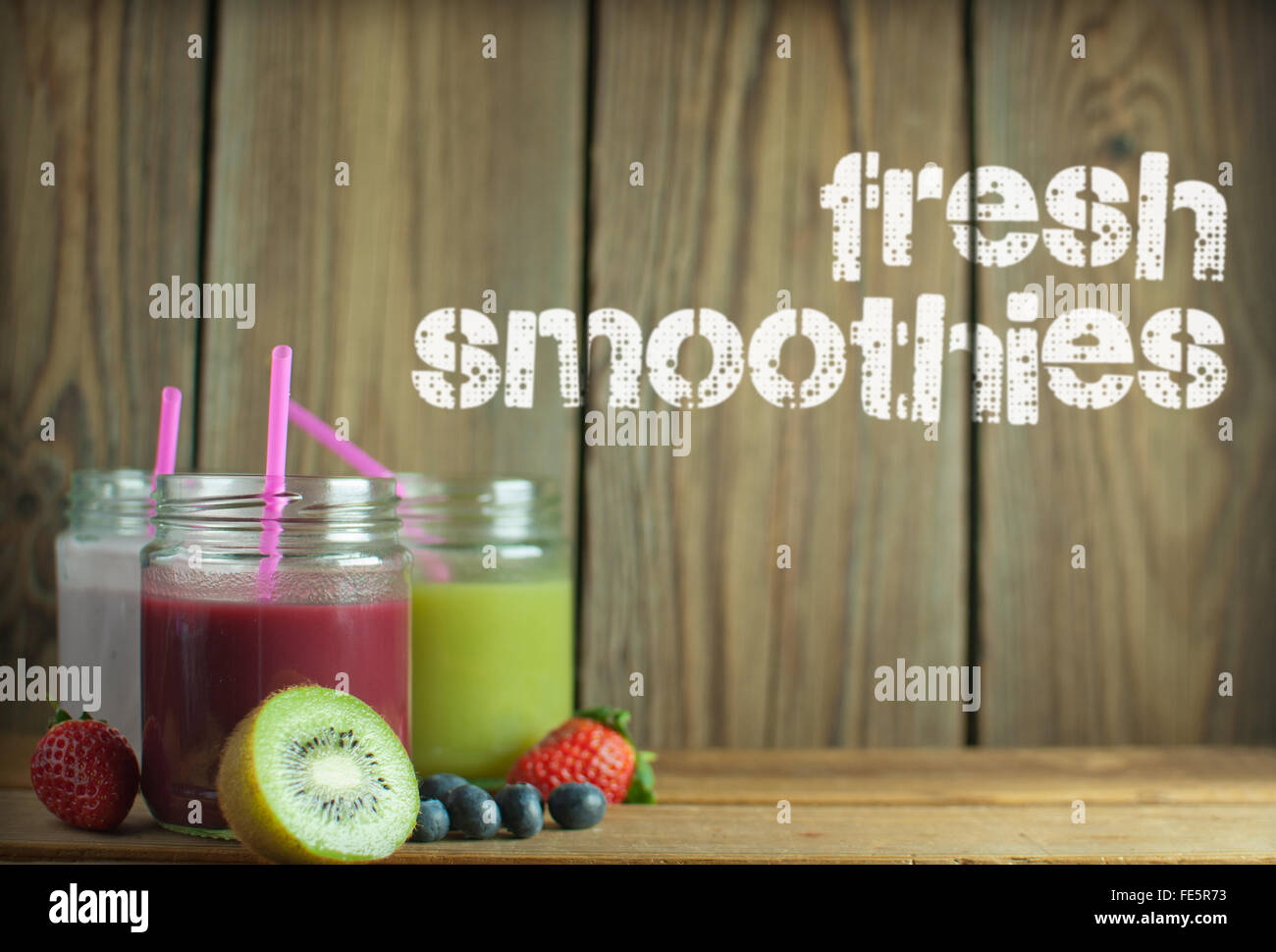 Aromatisierte Smoothies einschließlich Berry und Kiwi mit hölzernen Hintergrund Stockfoto