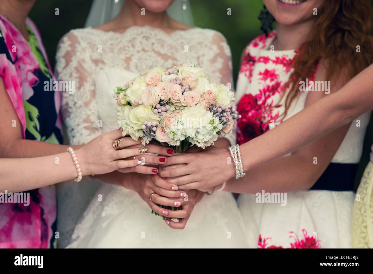 Braut mit einem weißen Blumenstrauß und Brautjungfern Stockfoto