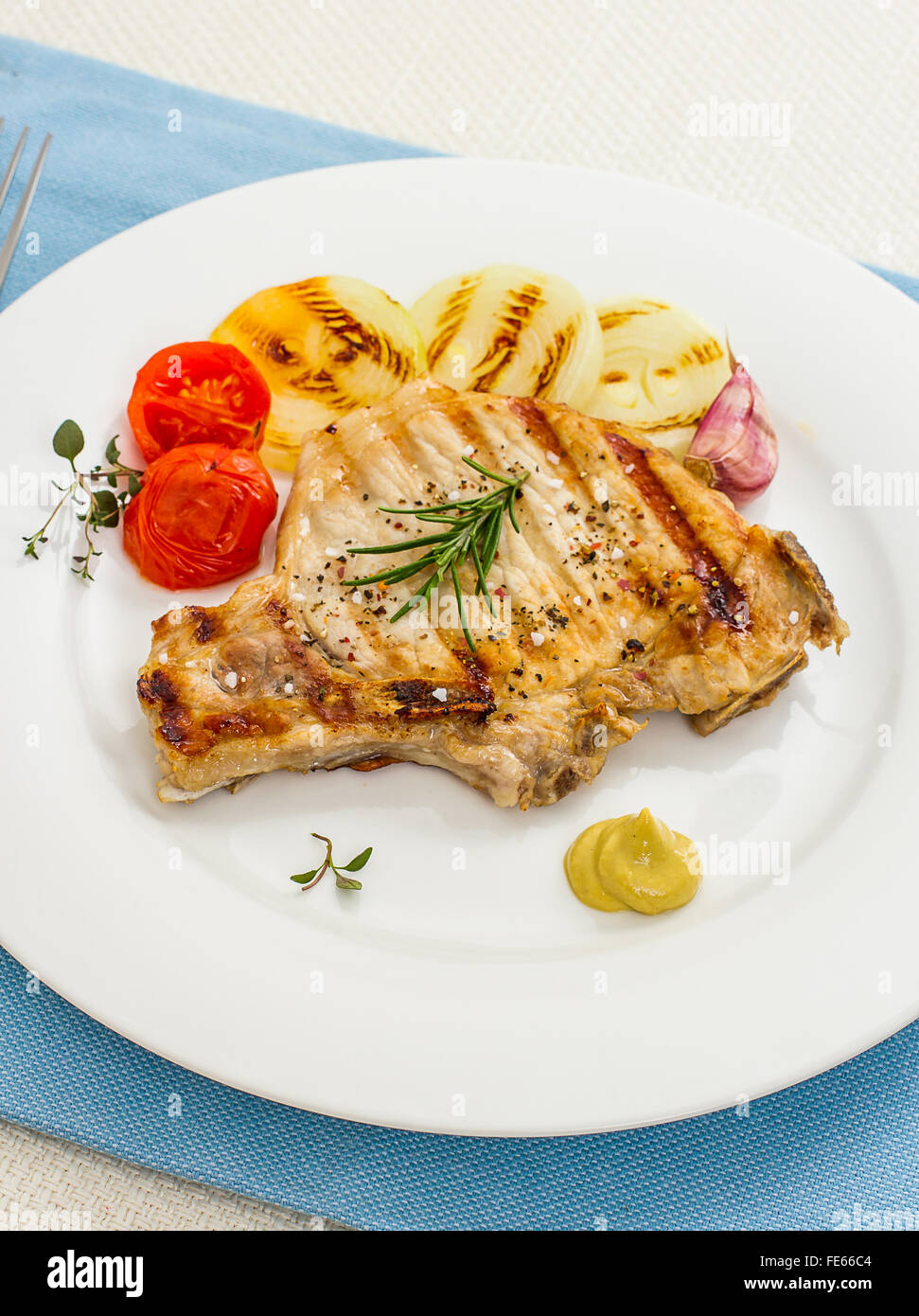 Gegrilltes Schweinekotelett mit Zwiebelringen und Senf, Ansicht von oben Stockfoto