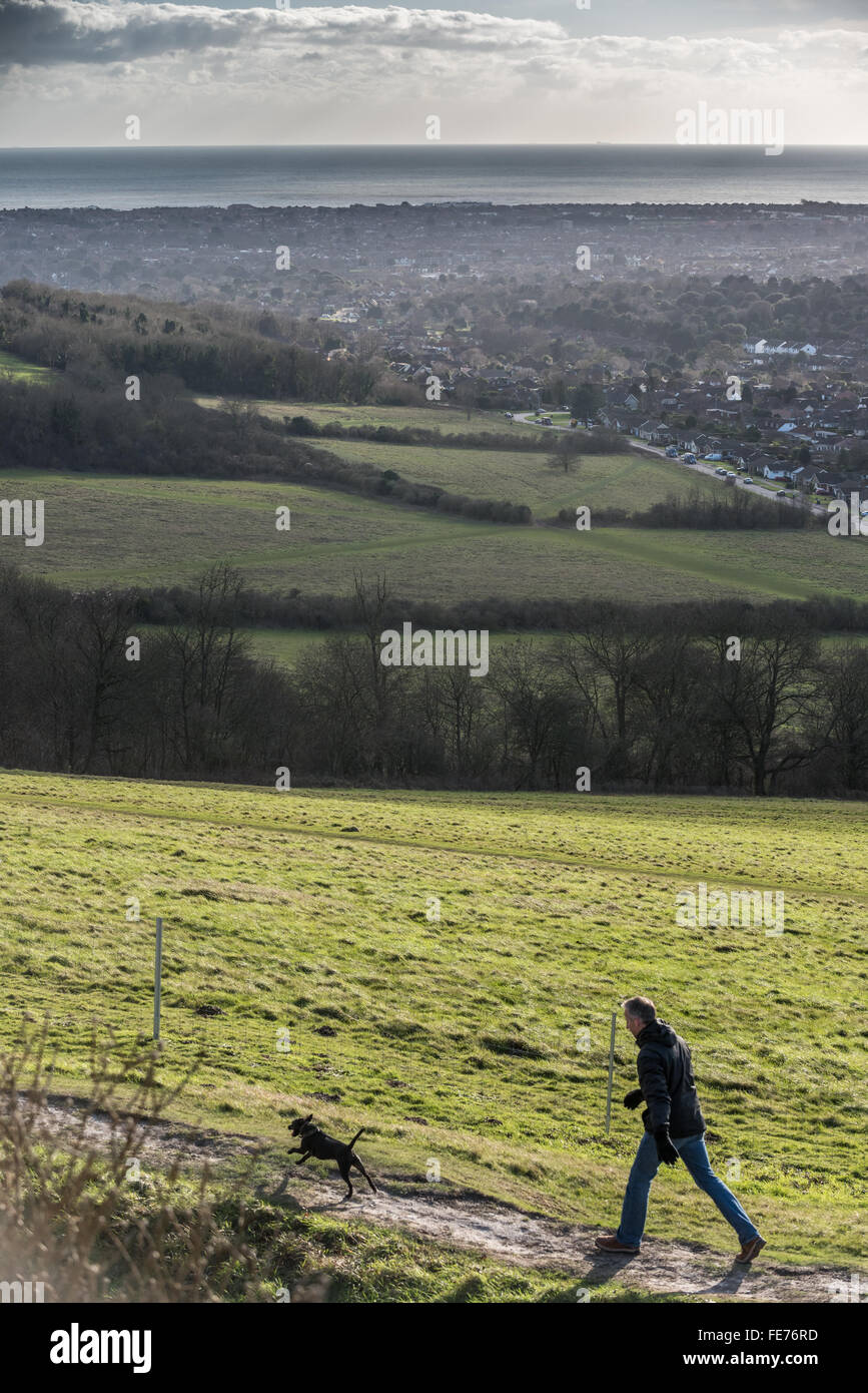 Ein Mann zu Fuß einen Hund auf Cissbury Ring Wallburg in Findon, West Sussex. Stockfoto