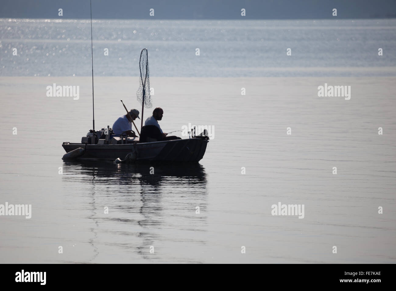 Zwei Männer in einem kleinen Motorboot, Angeln auf dem offenen Wasser. Stockfoto