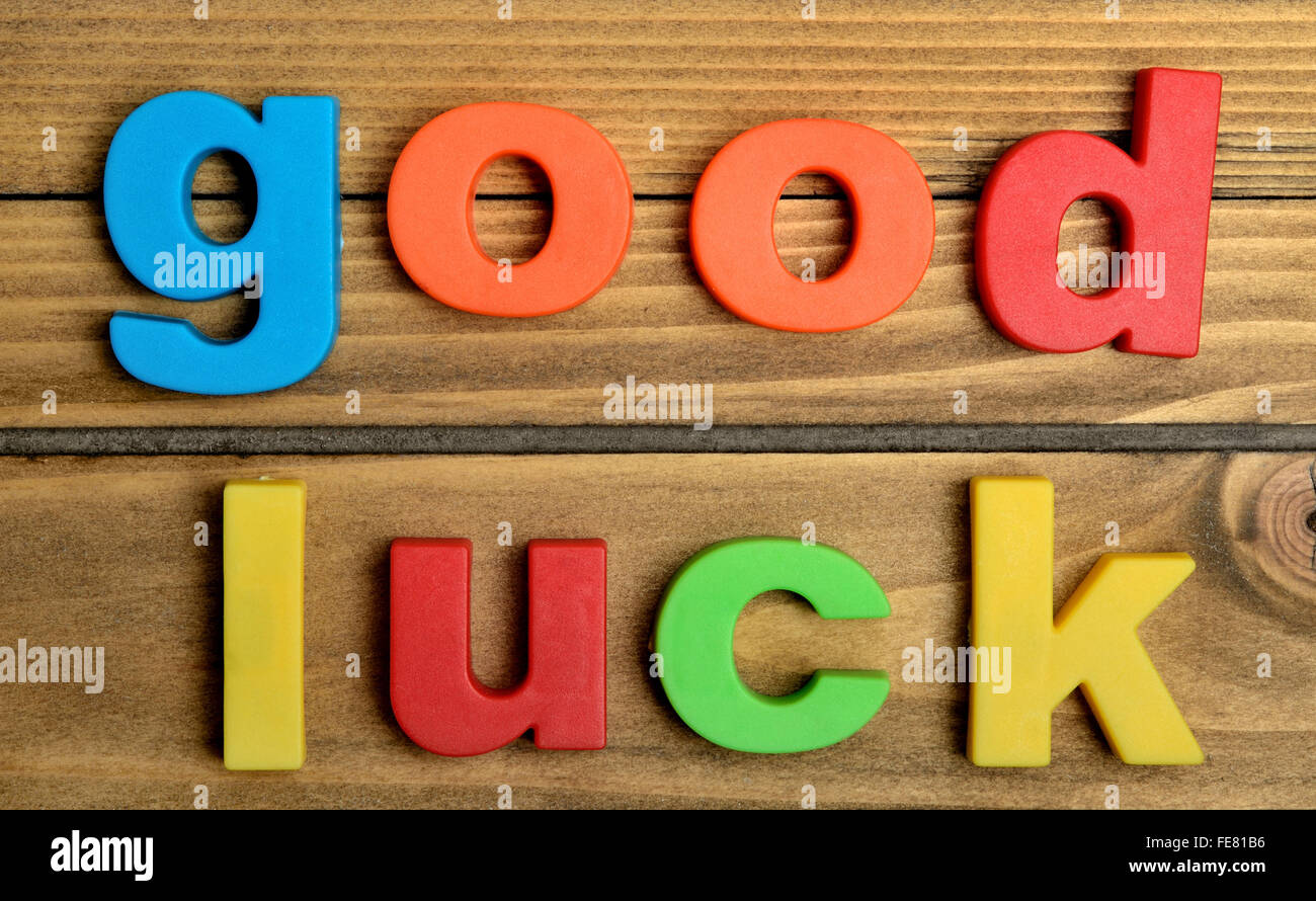 Buntes Glück Wort auf Holztisch Stockfoto