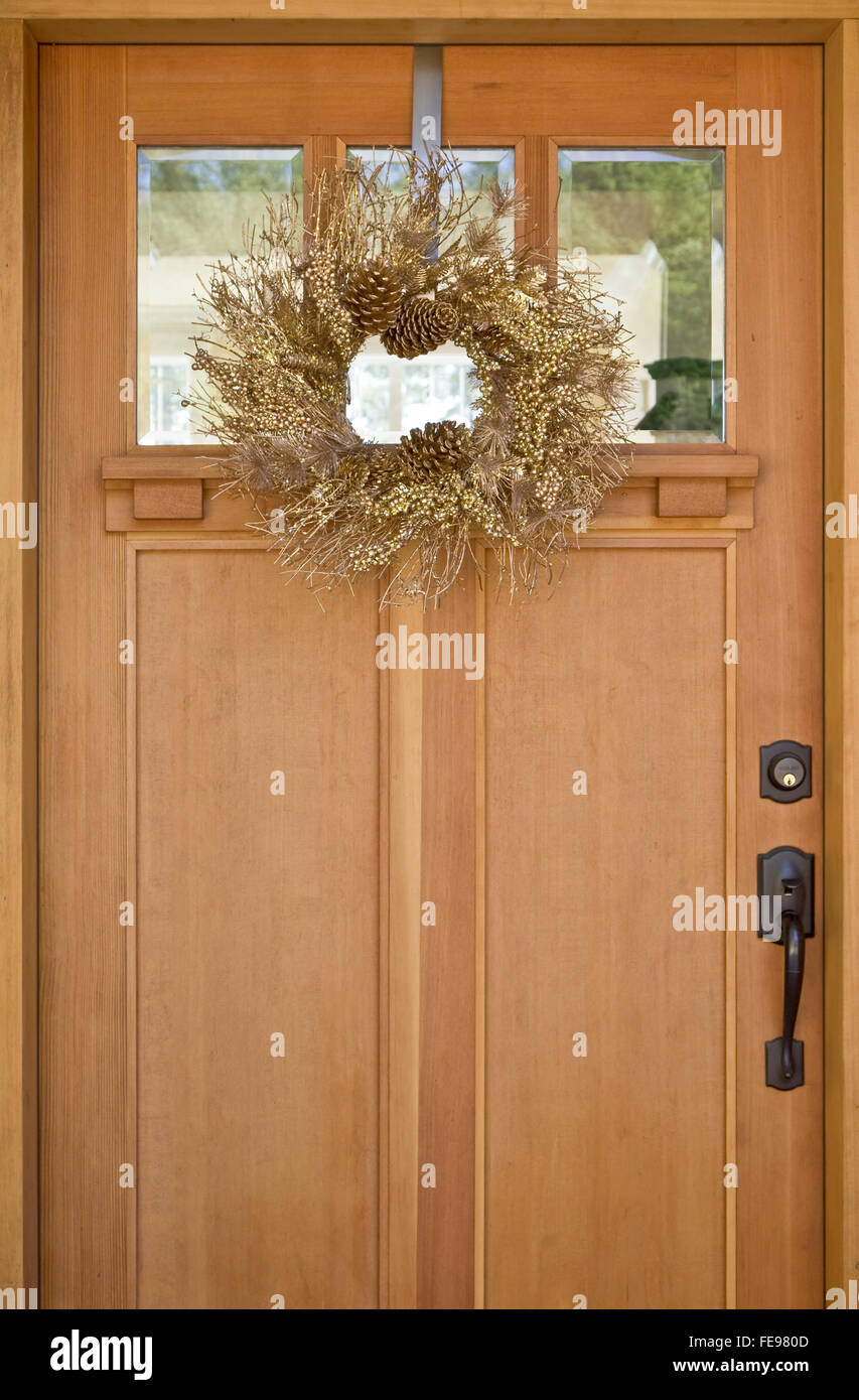 Schönen gold Kranz aufhängen auf hölzernen Tür. Einfache, natürliche, elegante Weihnachten Ferienhaus Dekorationen. Stockfoto