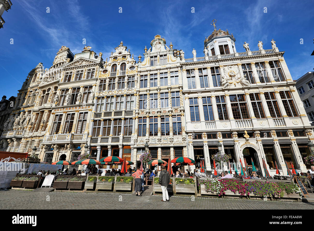 Einige Touristen machen Sie eine Pause und genießen Sie die Schönheit des Grand Place von Brüssel vor neu restaurierte Fassaden Stockfoto