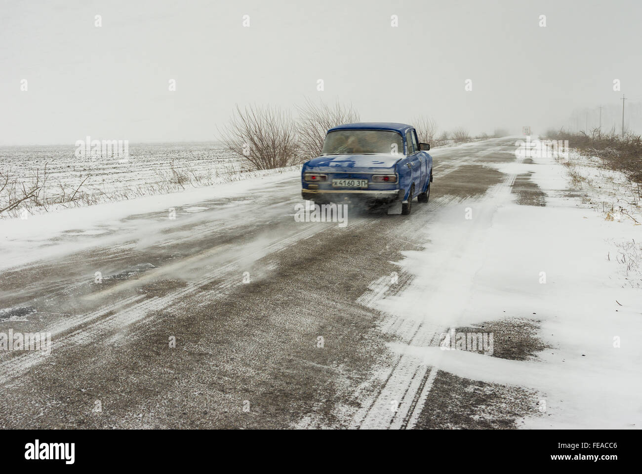 Skelky, Oblast Saporischschja, Ukraine - 27. Dezember 2014: Private Oldtimer auf einem verschneiten Autobahn Kampf vorwärts durch Schneeverwehungen Stockfoto