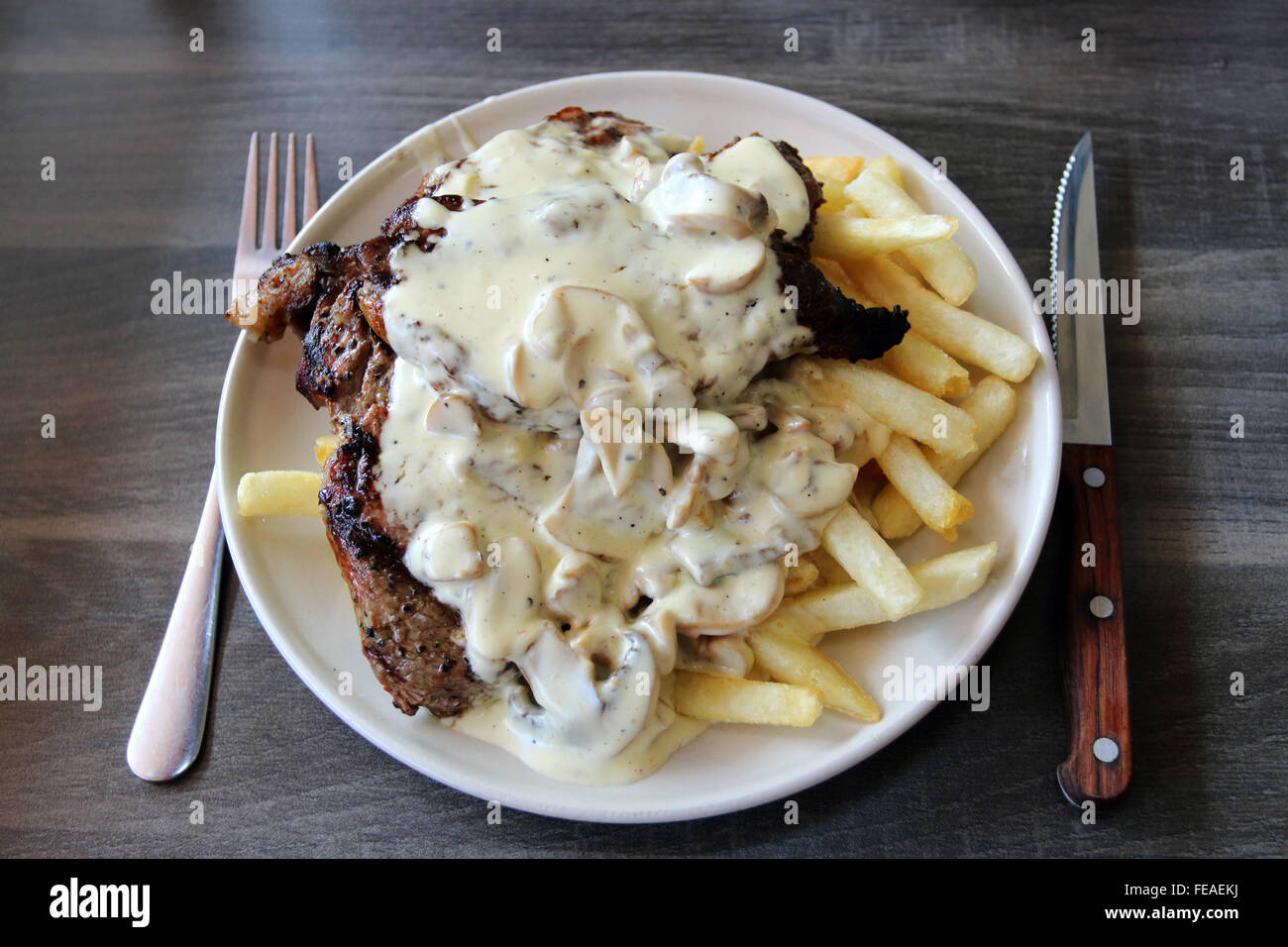 Steak und Chips mit cremiger Pilzsauce Stockfoto