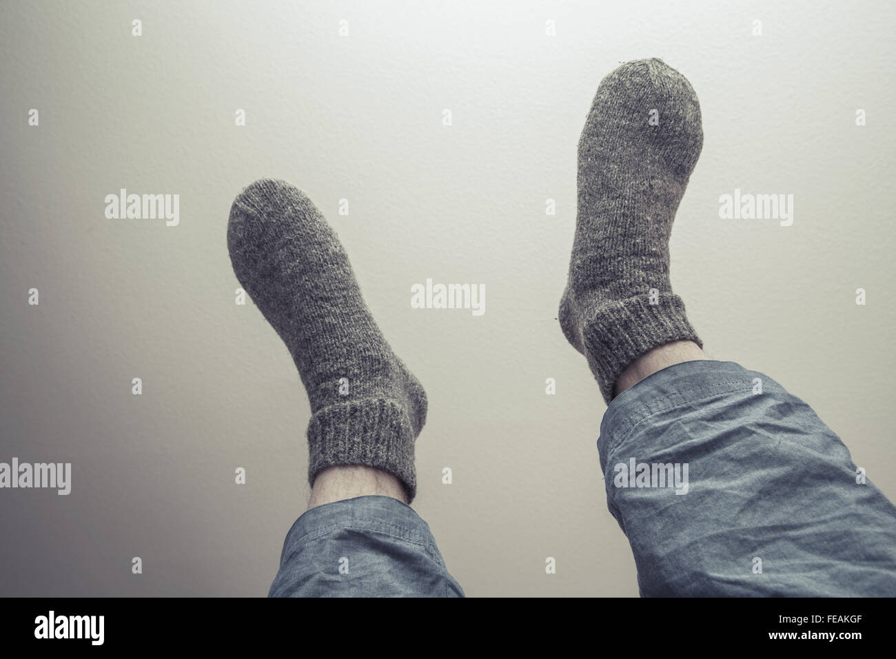 Männliche Füße in graue Wollsocken, Retro-Stil-Tonwertkorrektur-Foto-filter Stockfoto
