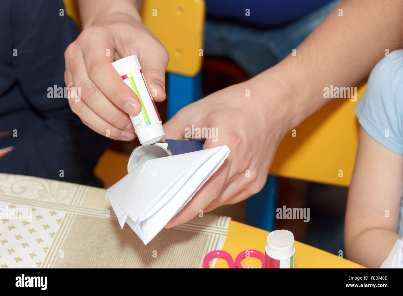 Mann kleben Hände Sie Papier Handwerk auf der Schulbank Stockfoto