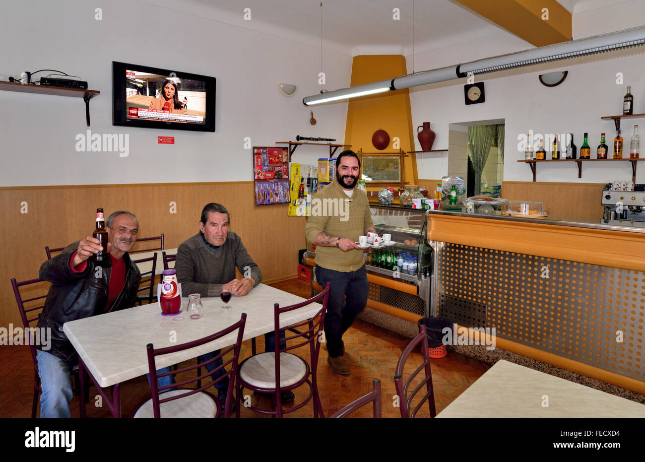 Portugal, Alentejo: Barbesitzer Sérgio servieren Kaffee mit Kunden mit einem Drink im Retired´s Club in Mina de São Domingos Stockfoto