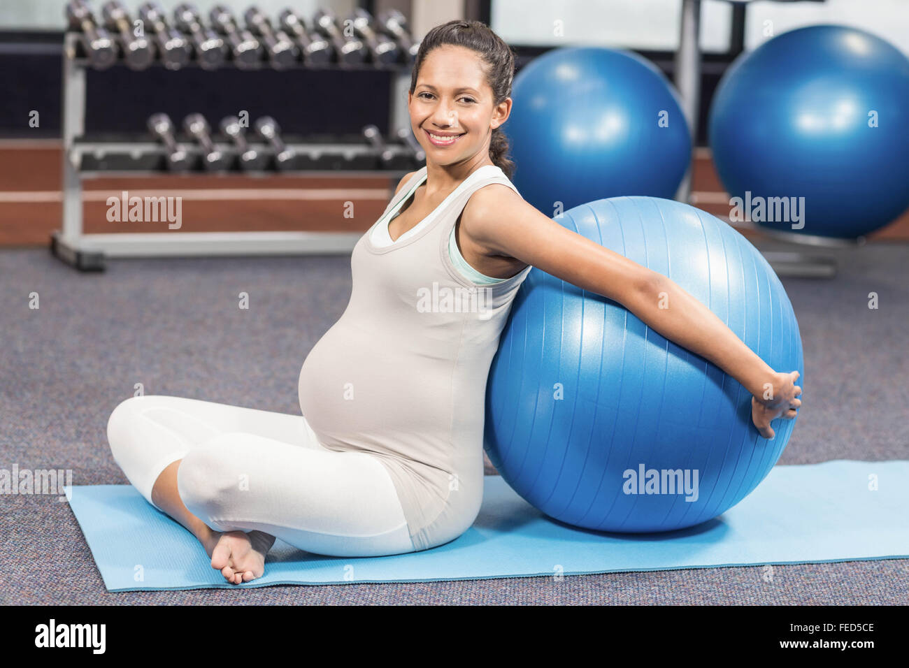 Schwangere Frau lehnt sich zurück auf Fitness-ball Stockfoto