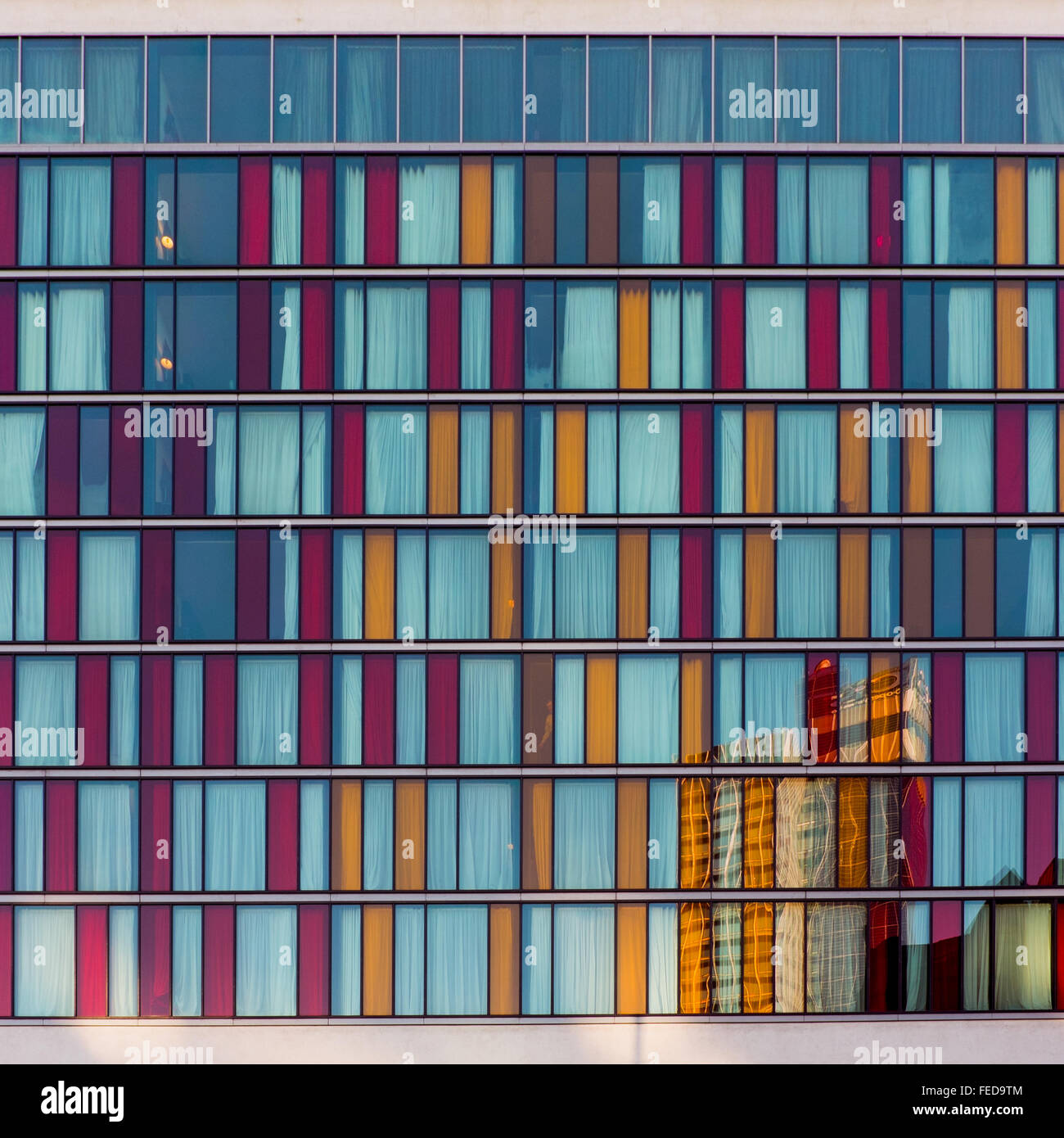 Die farbigen Glas Fenster des Crowne Plaza Hotel in der nördlichen Viertel Manchester mit einer Reflexion des GUS-Gebäudes Stockfoto