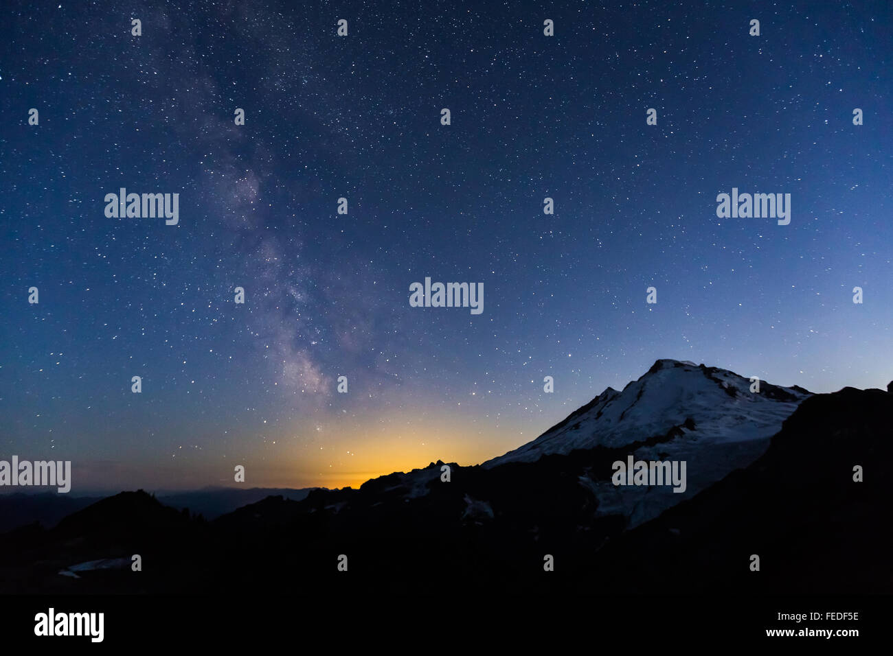 Mount Baker mit Milky Way und unzähligen Sternen und Glühen von Bellingham, angesehen vom Ptarmigan Ridge, Washington State, USA Stockfoto