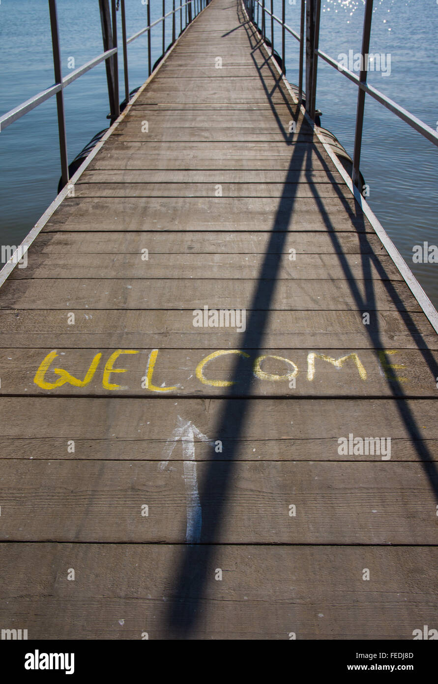 Willkommens-Schild auf einem schwimmenden Steg Holzfußboden gemalt. Stockfoto