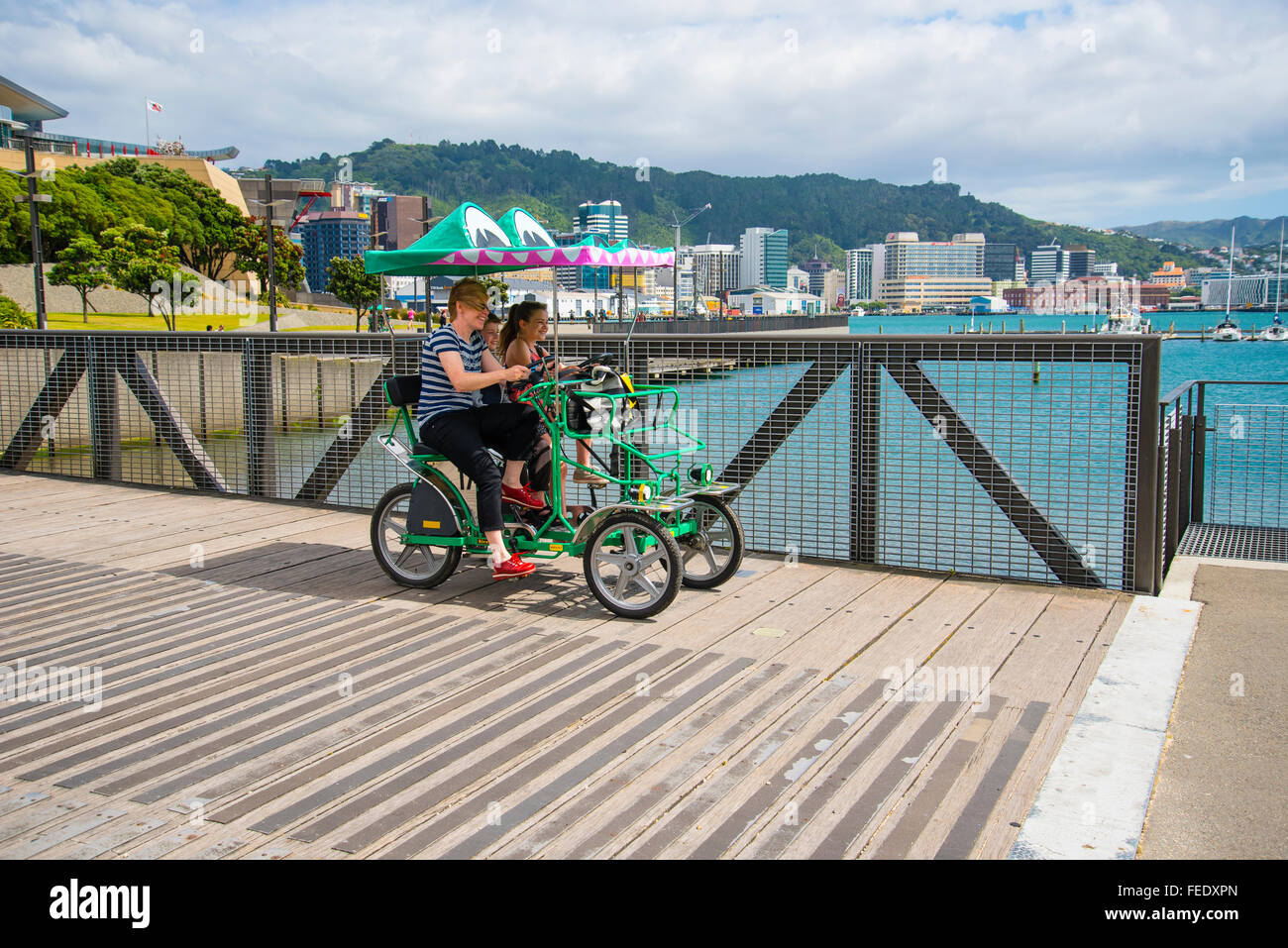 Familie in Surrey Fahrrad oder Quadracycle an der Uferpromenade in Wellington New Zealand Stockfoto