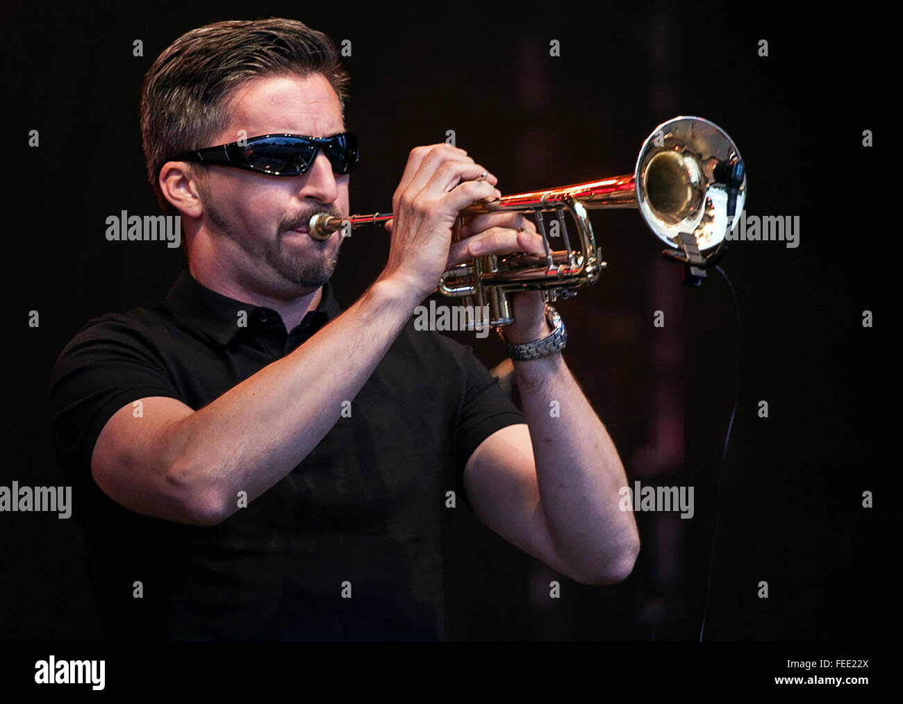 Cool sieht Mann eine Trompete auf der Bühne tragen dunkle Glas Stockfoto