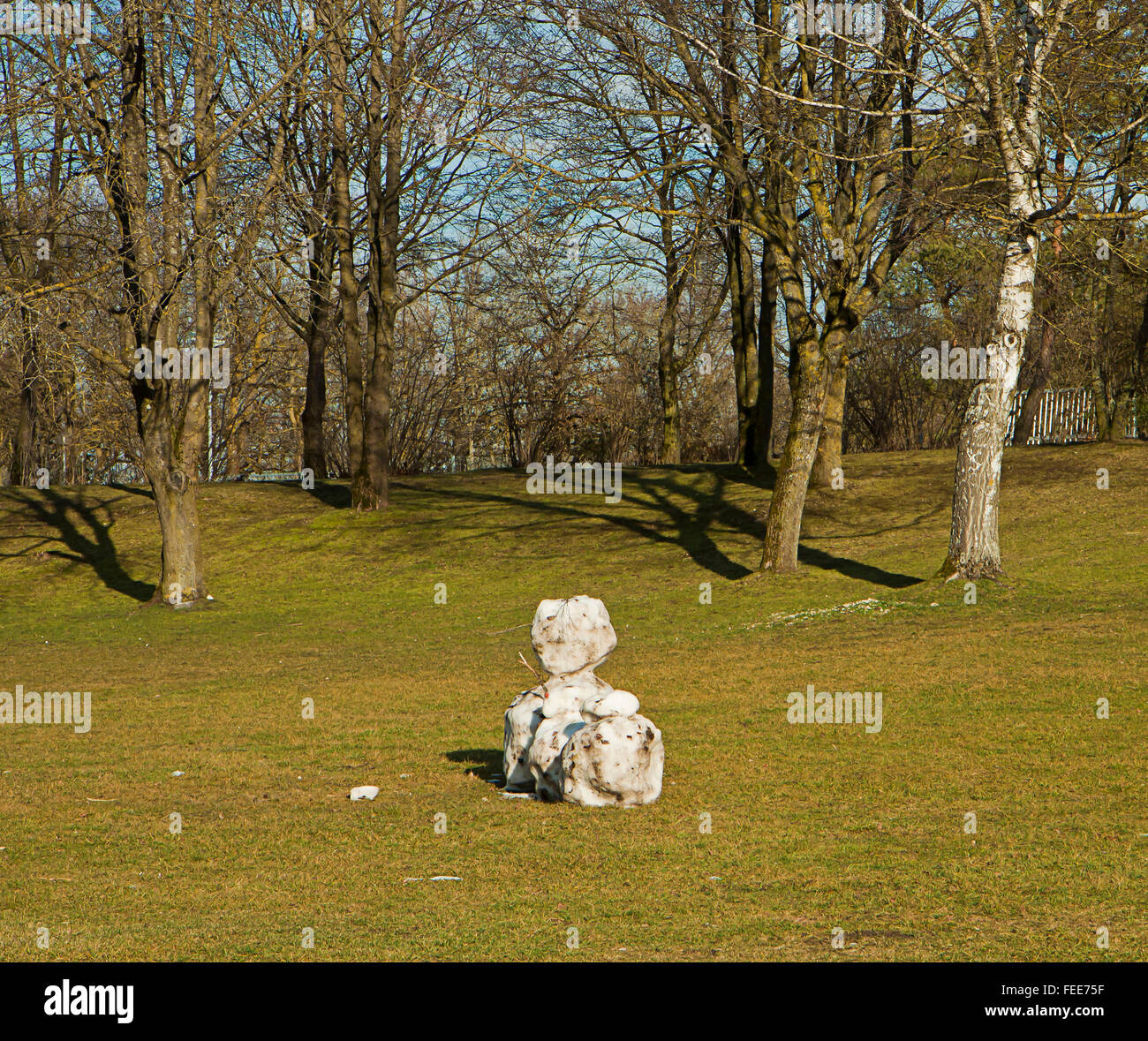 Schneemann in der Sonne, mit Landschaft grün wieder Schnee schmelzen Stockfoto