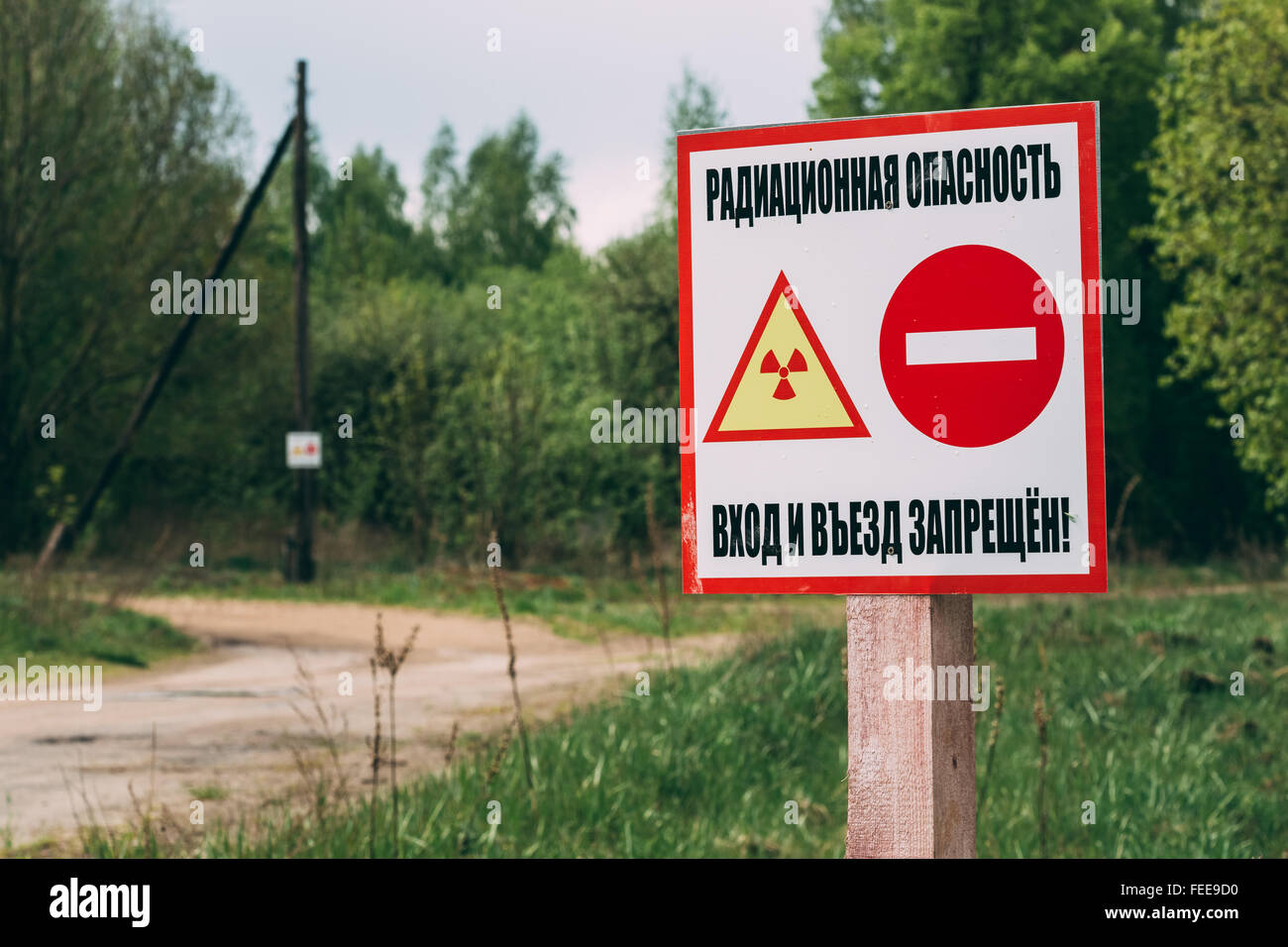 Warnschild ionisierender Strahlung in der Nähe des Dorfes in der Region Gomel, Weißrussland. Strahlungsbereich Kontamination. Stockfoto