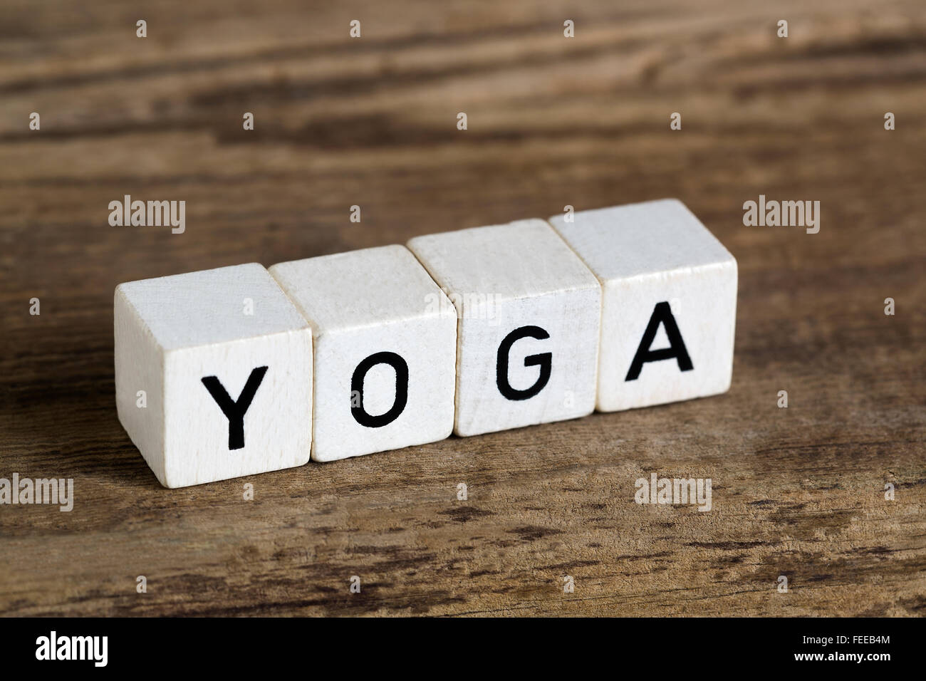 Das Wort Yoga geschrieben in Würfeln auf einem hölzernen Hintergrund Stockfoto