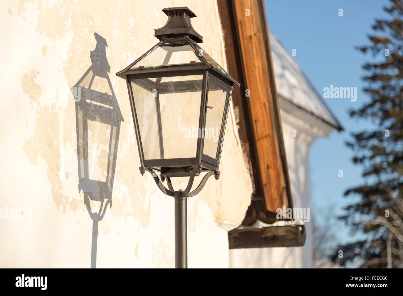 Alt-Straßenleuchte mit seinem Schatten an der Wand Stockfoto