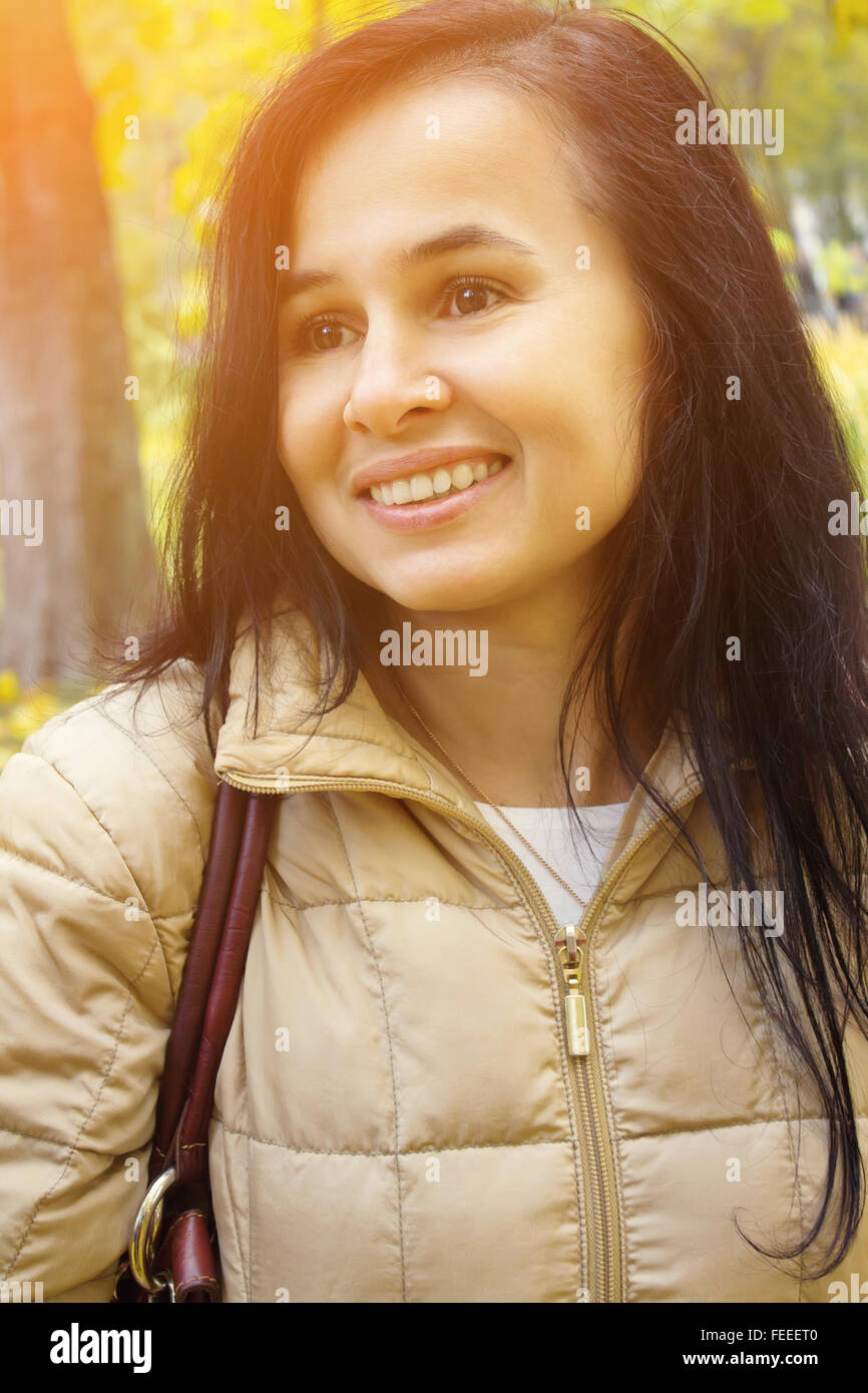 Glückliche junge schöne Frau geht im Herbst Park spazieren. Stockfoto