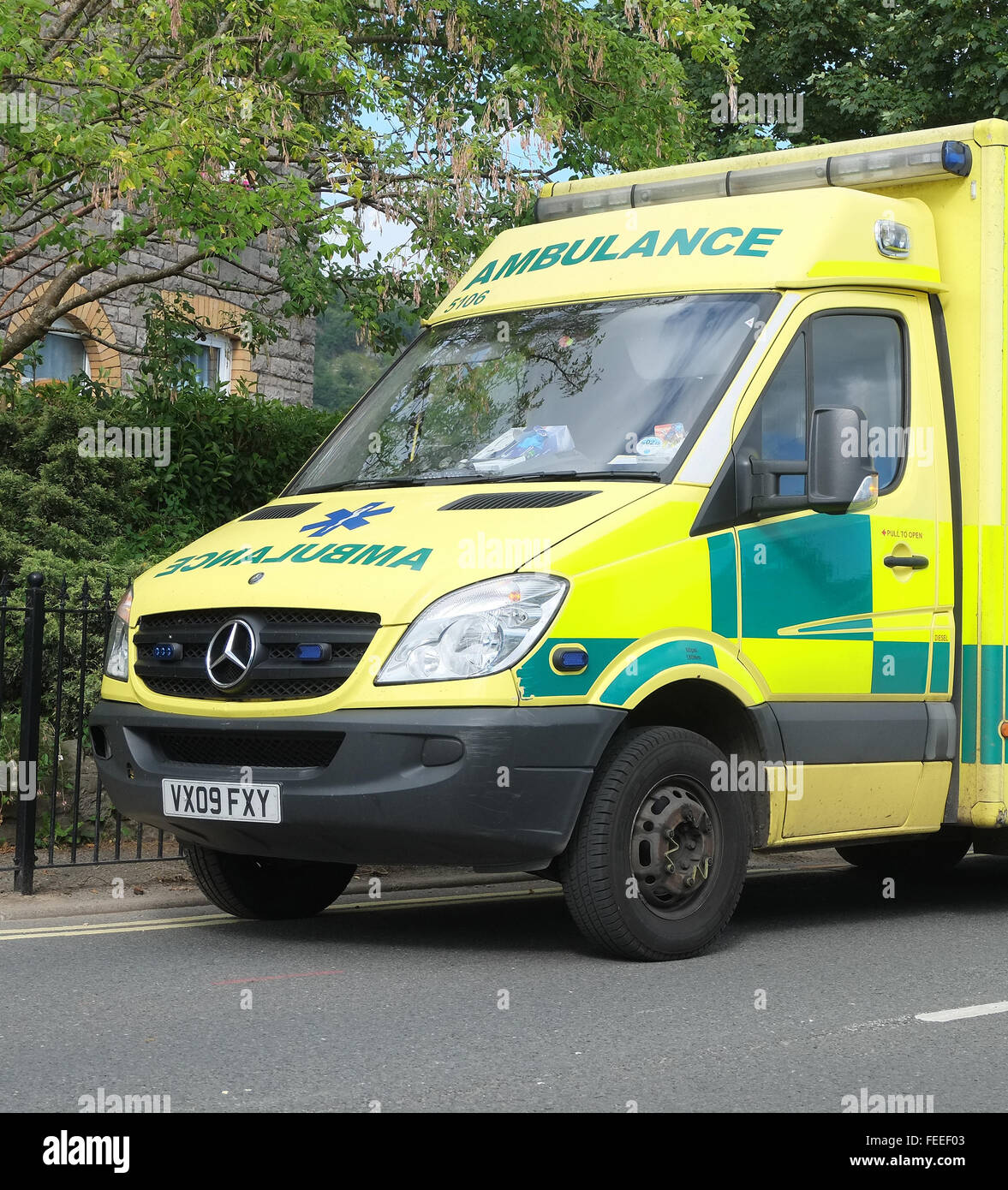 Britische Krankenwagen geparkt am Straßenrand, während die Crew mit einem Patienten im Haus sind. Stockfoto