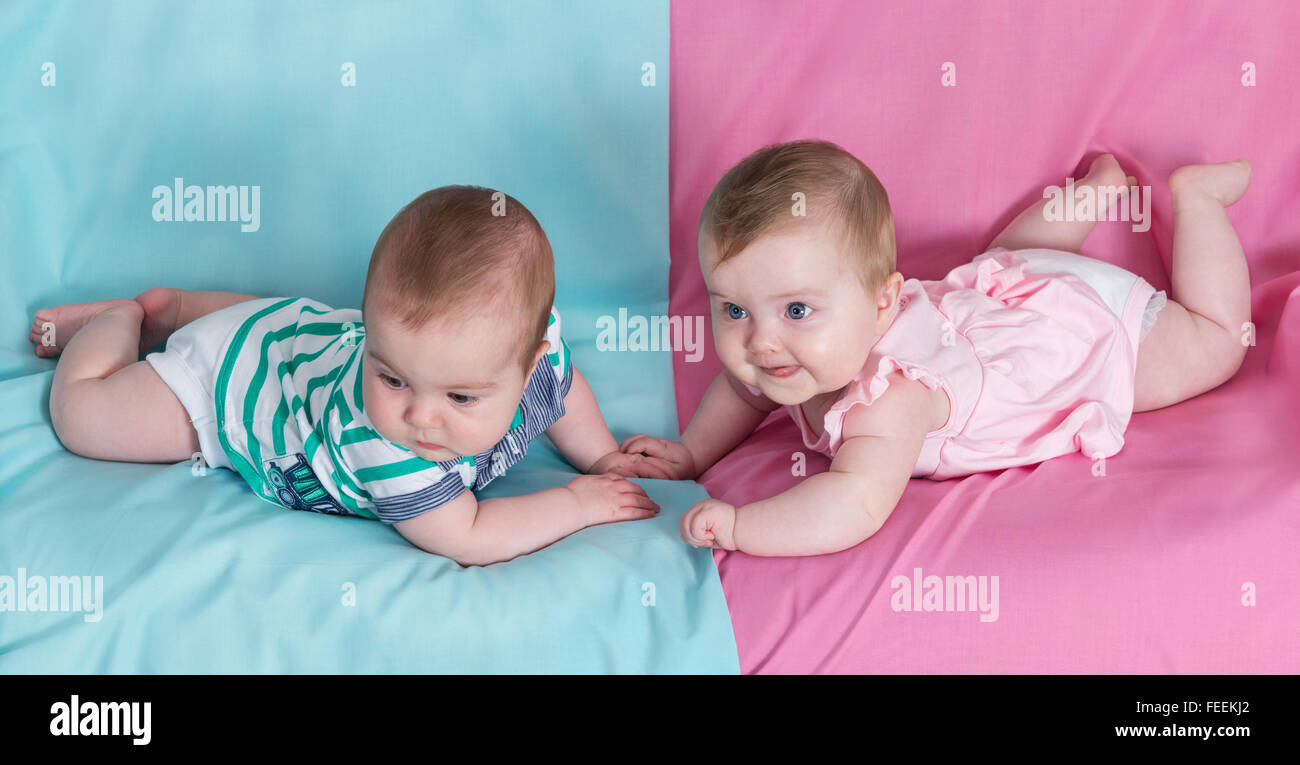 Bruder und Schwester - Zwillinge Babys Mädchen und Jungen auf rosa und blauen Hintergrund Stockfoto