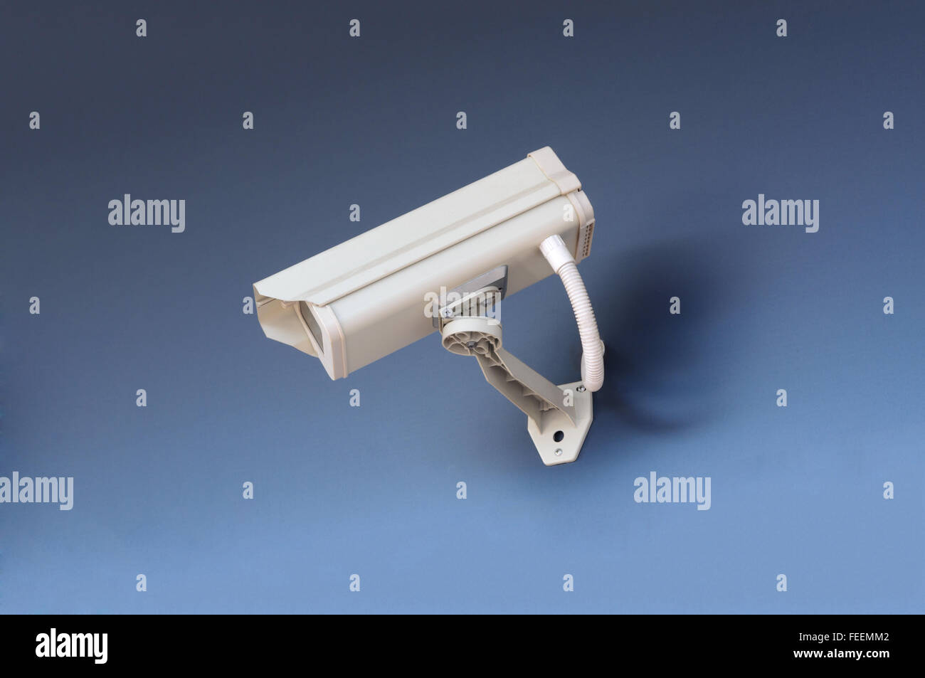 CCTV-Überwachungskamera im Bürogebäude auf blauem Hintergrund. Stockfoto