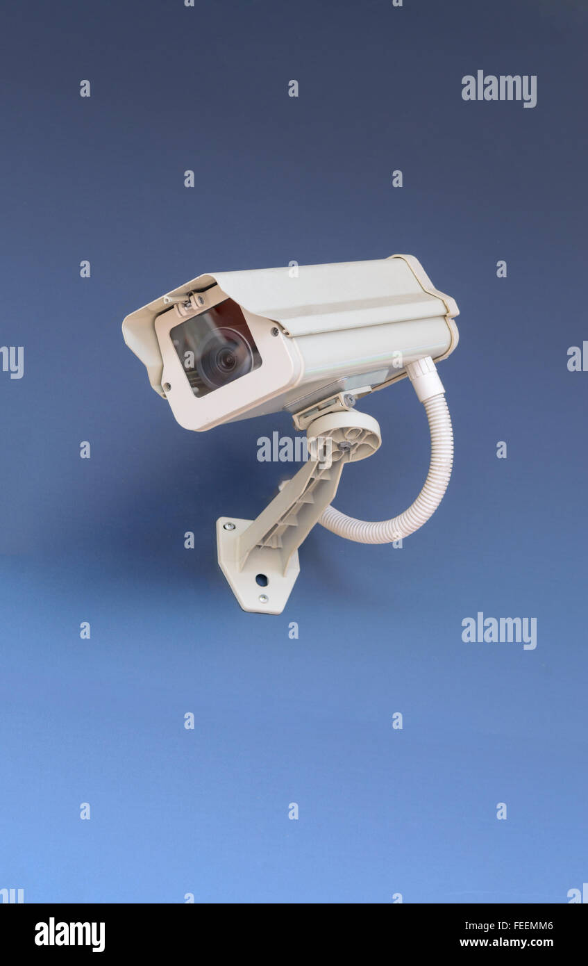 CCTV-Überwachungskamera im Bürogebäude auf blauem Hintergrund. Stockfoto