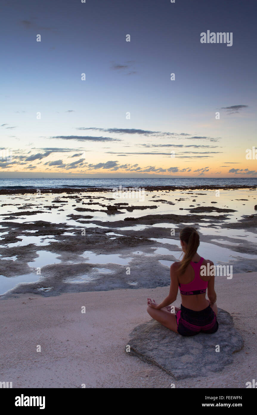 Frau praktizieren Yoga am Strand bei Sonnenaufgang, Fakarava, Tuamotu-Inseln, Französisch-Polynesien Stockfoto