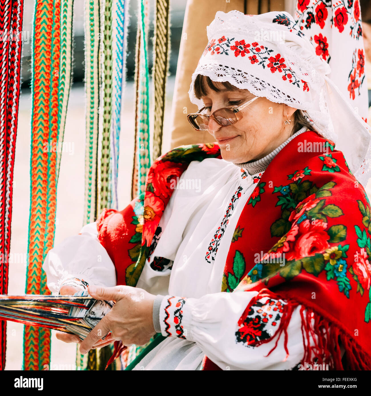 Gomel, Weißrussland - 12. September 2015: Frau in nationalen belarussischen Tracht weben Riemen Stockfoto