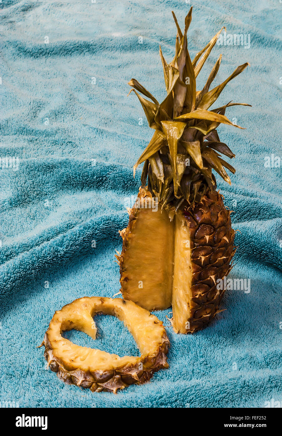 Ananas und seine Schicht mit einem herzförmigen Ausschnitt liegen auf blauem Hintergrund Stockfoto