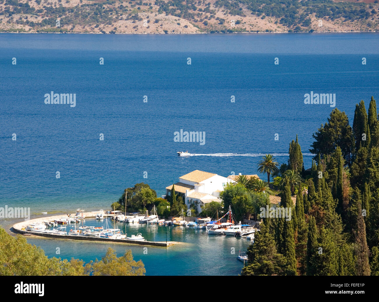 Kringels, Korfu, Ionische Inseln, Griechenland. Blick über den Hafen auf die Meerenge von Korfu und entfernten Küste Albaniens. Stockfoto