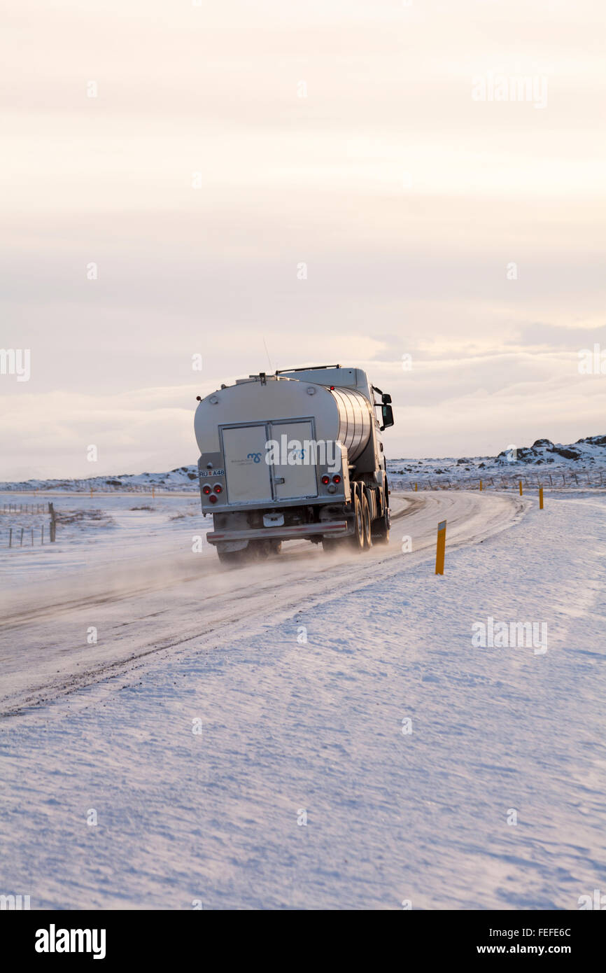 Tanker Fahrt entlang der Straße durch schneebedeckte Berge in Island im Februar Stockfoto