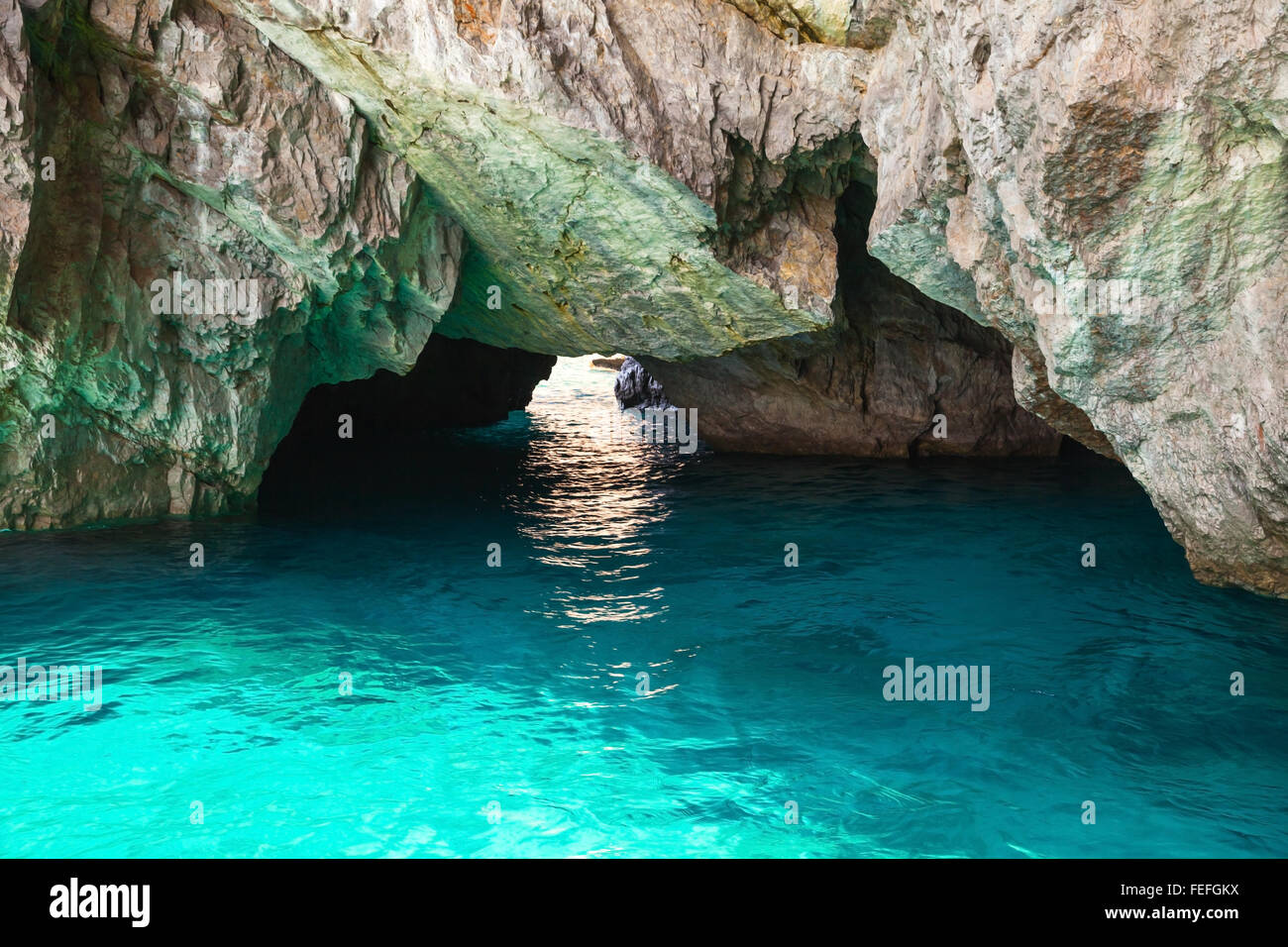 Küstenfelsen der Insel Capri, kleine leere Grotte mit leuchtenden Meerwasser im Inneren Stockfoto