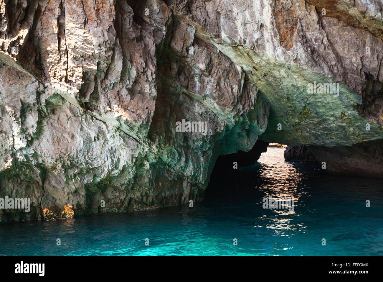 Küstenfelsen der Insel Capri, kleine Grotte mit leuchtenden Meerwasser im Inneren Stockfoto