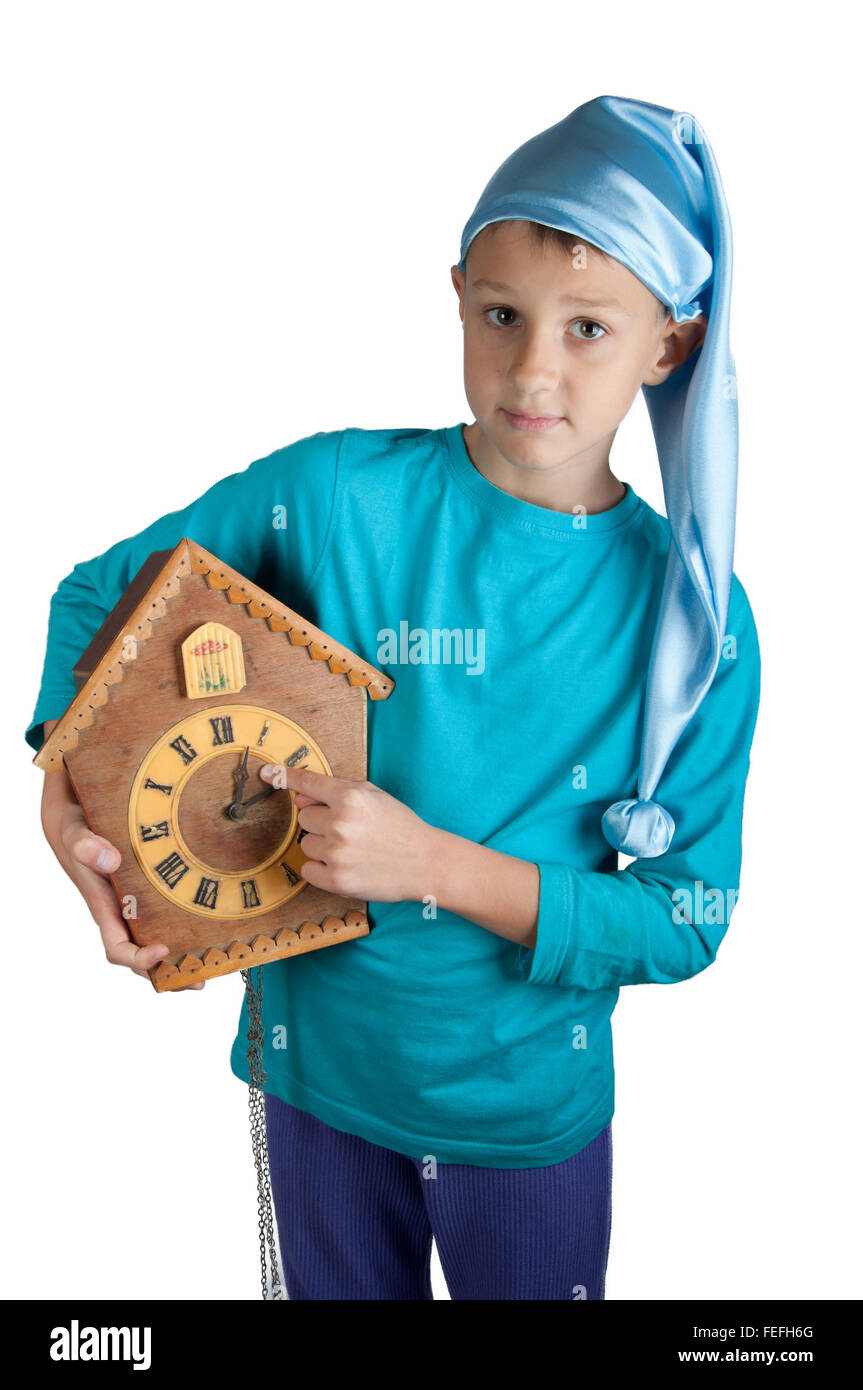 Süsser Boy in blauen Schlafanzug und schlafenden Hut hält Uhr isoliert auf weiss Stockfoto