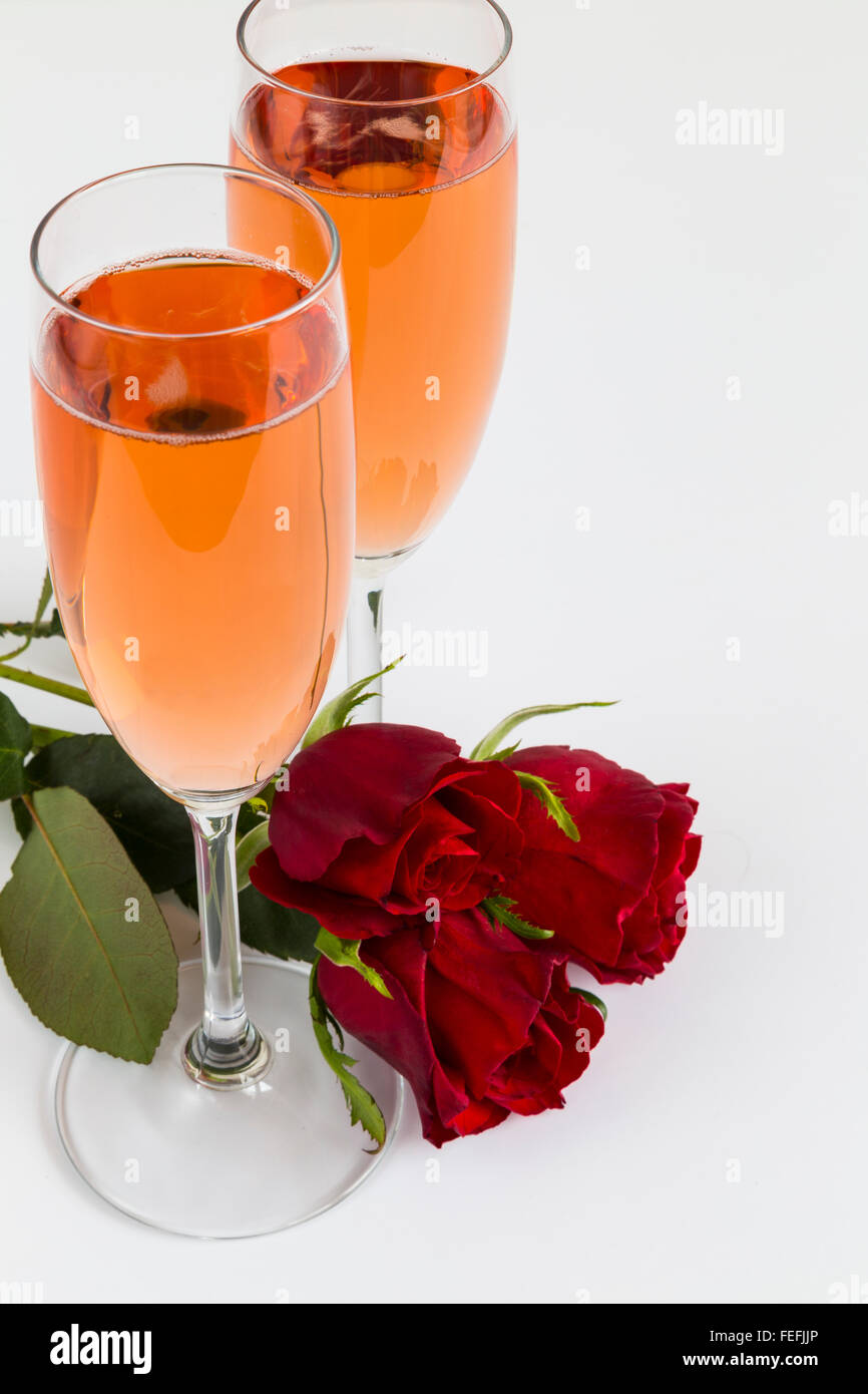 Rosé-Champagne-Flöten mit Rosen Stockfoto