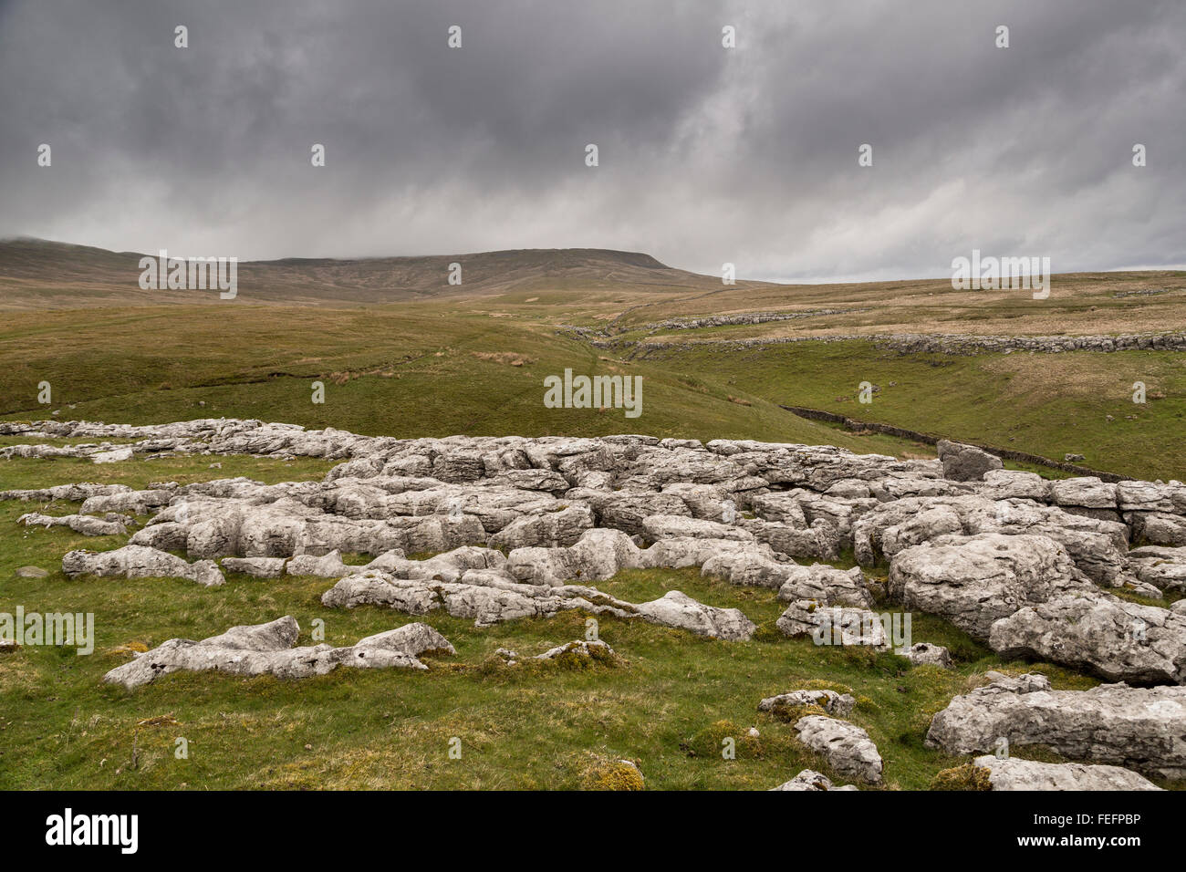 Kalkstein Pflaster auf Ingleborough, Yorkshire Dales, UK mit Höhlenforscher zu Fuß zum Gaping Gill Stockfoto
