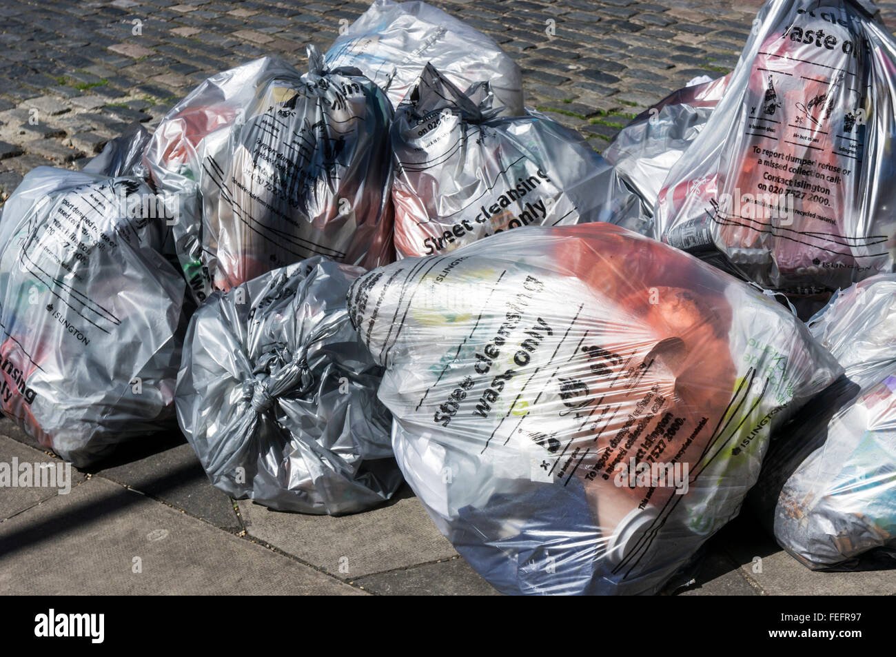 Taschen der Straßenreinigung Abfallsammlung warten neben einer Straße in Islington, London. Stockfoto