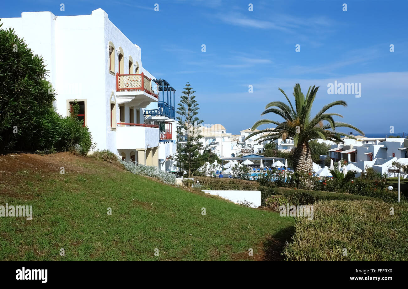 Gebäude mit roten Balcones und Palmen im High class griechischen Hotel Aldemar Cretan Village, Kreta, Griechenland. Stockfoto