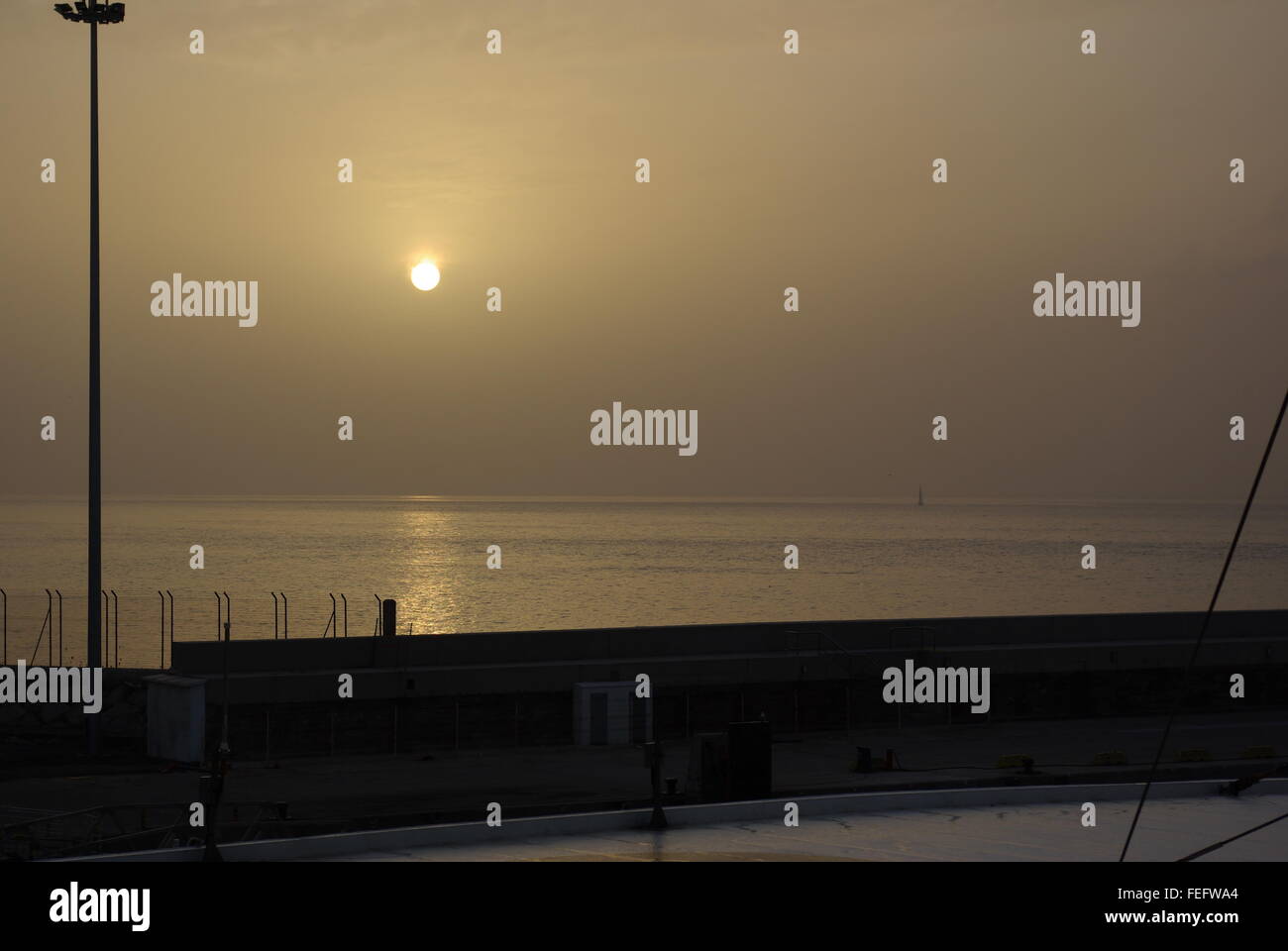 Sonnenaufgang durch den Dunst, der sich über dem Meer spiegelt, Tarifa, Andalusien, Spanien Stockfoto