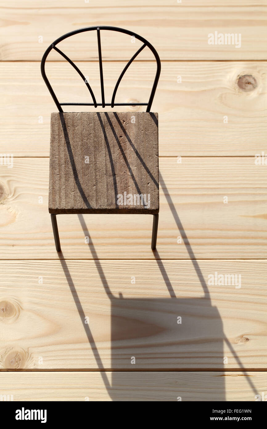 Stuhl und Schatten auf dem Holzboden Stockfoto