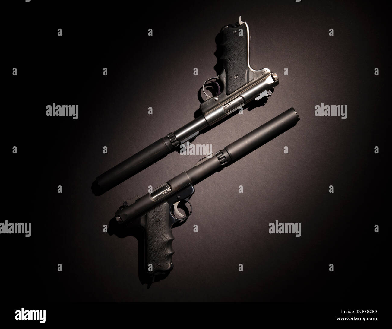 Zwei halbautomatische Pistolen mit Schalldämpfern auf schwarzem Hintergrund. Stockfoto