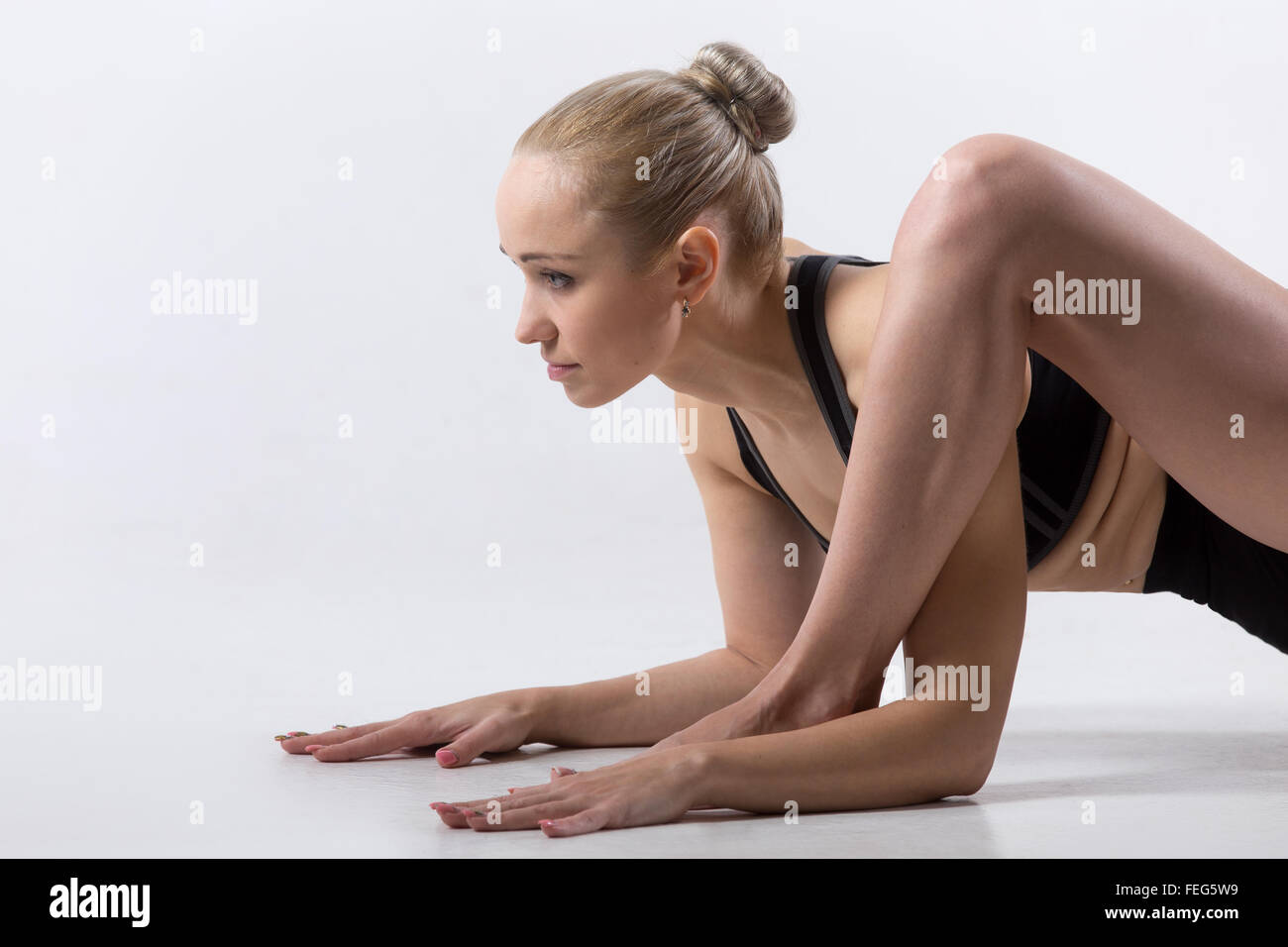 Porträt von sportlich schöne junge Frau, Yoga zu praktizieren, niedrige Longe Übung, Hüft-Öffner Utthan Pristhasana Eidechse darstellen Stockfoto